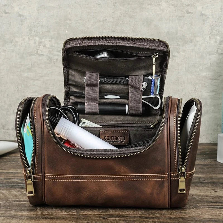 Trousse de toilette en cuir marron personnalisée, ouverte, montrant un intérieur spacieux et des compartiments.
