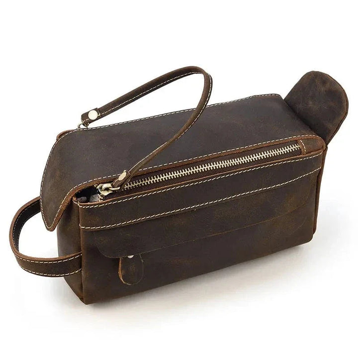 Détail de la poignée en cuir d'une trousse de toilette homme, robuste et pratique.