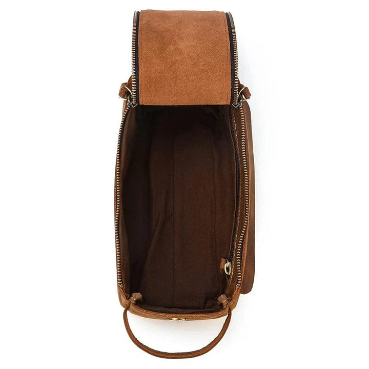 Intérieur d'une trousse de toilette homme en cuir, compartiments organisateurs visibles.
