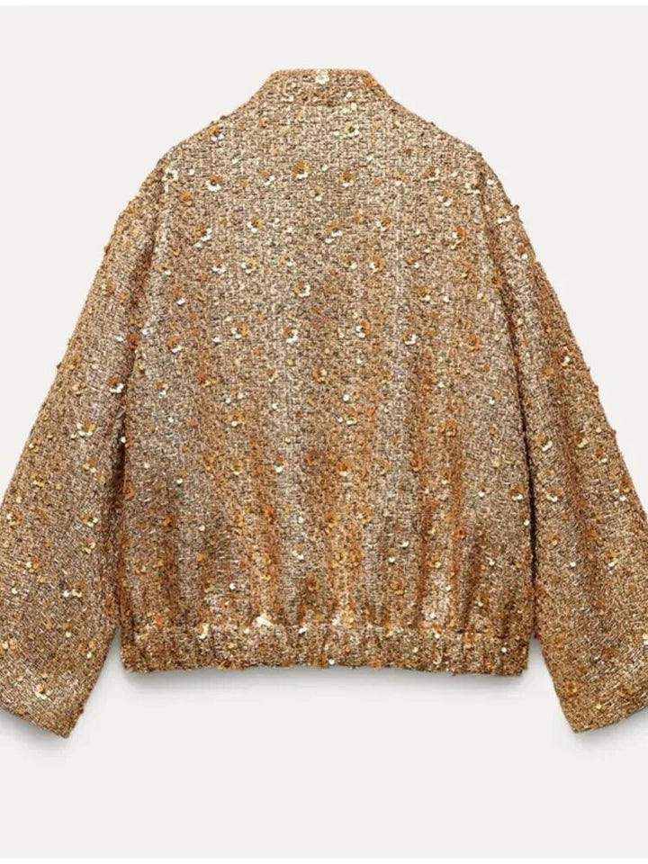 Femme élégante portant la veste bomber Lynn dorée, look moderne pour la mode automne-printemps.