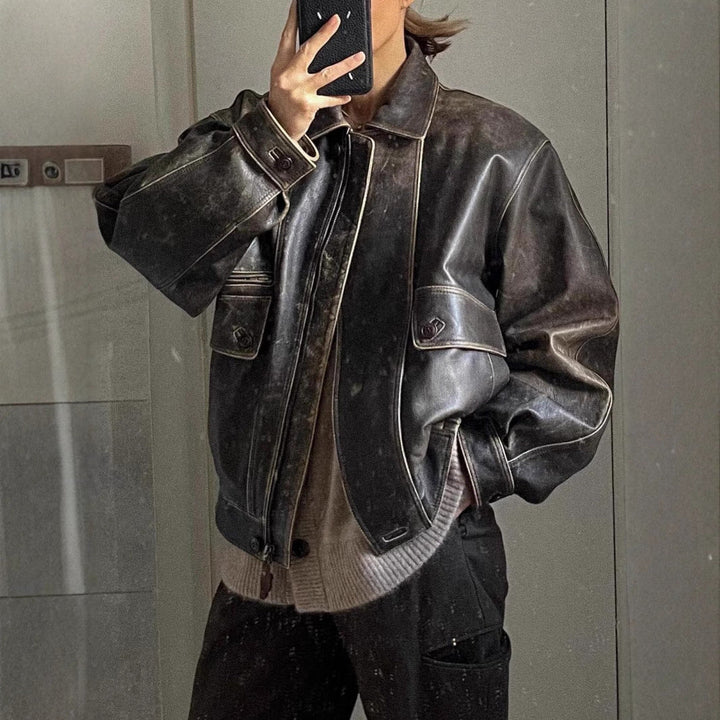 "Veste courte vintage en cuir vieilli, style rétro avec zip et poches boutonnées, parfait pour look urbain chic."