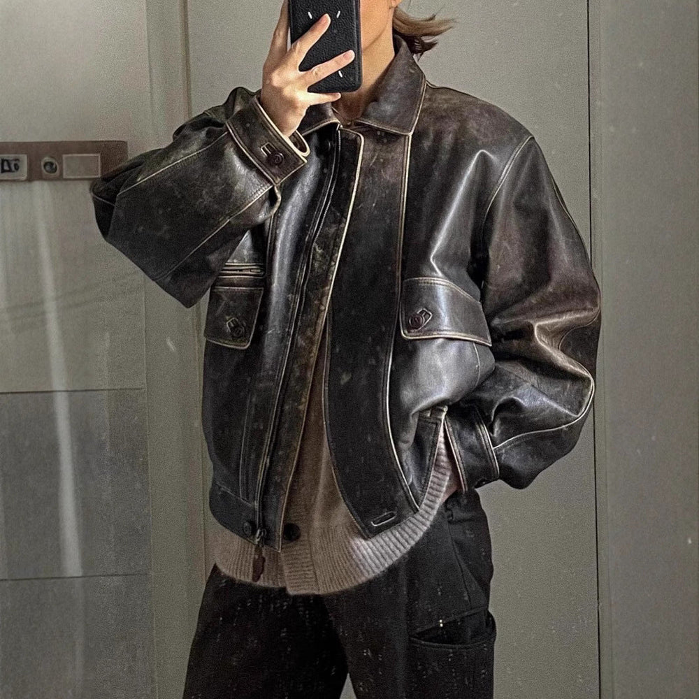 "Veste courte vintage en cuir vieilli, style rétro avec zip et poches boutonnées, parfait pour look urbain chic."