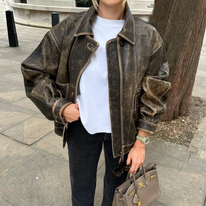 "Veste courte vintage en cuir vieilli, style rétro avec zip et poches boutonnées, parfait pour look urbain chic."
