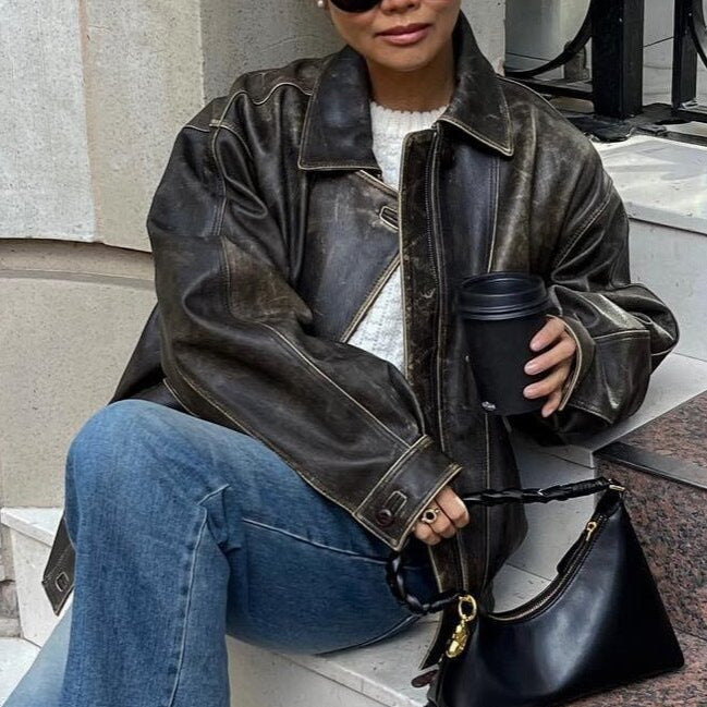"Veste courte vintage en cuir vieilli, style rétro avec zip et poches boutonnées, parfait pour look urbain chic."
