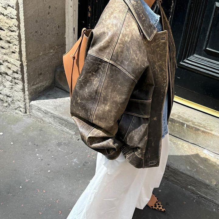 "Veste courte vintage en cuir vieilli, style rétro avec zip et poches boutonnées, parfait pour look urbain chic."
