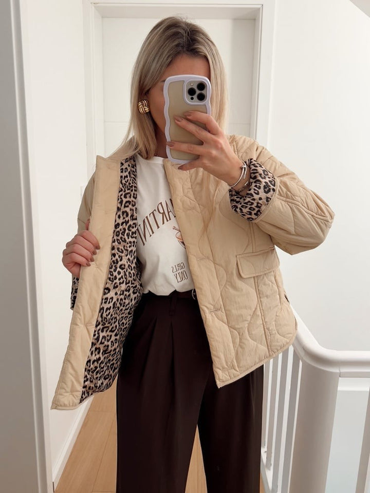 Veste élégante, coupe ajustée. Doublure léopard discrète. Chic et moderne.