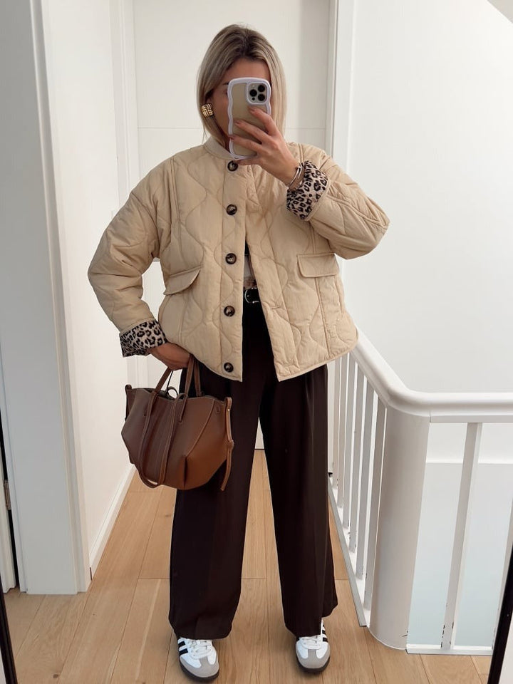 Veste élégante, coupe ajustée. Doublure léopard discrète. Chic et moderne.