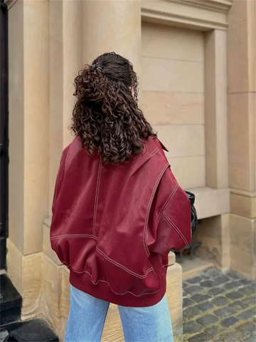 Veste en cuir rouge pour femme, coupe ample, col revers, style chic et intemporel.