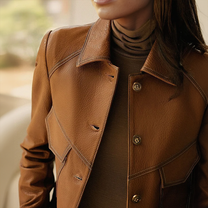 Gros plan sur la veste femme marron, détaillant son col distinctif et ses poches chic. Élégance et mode féminine.