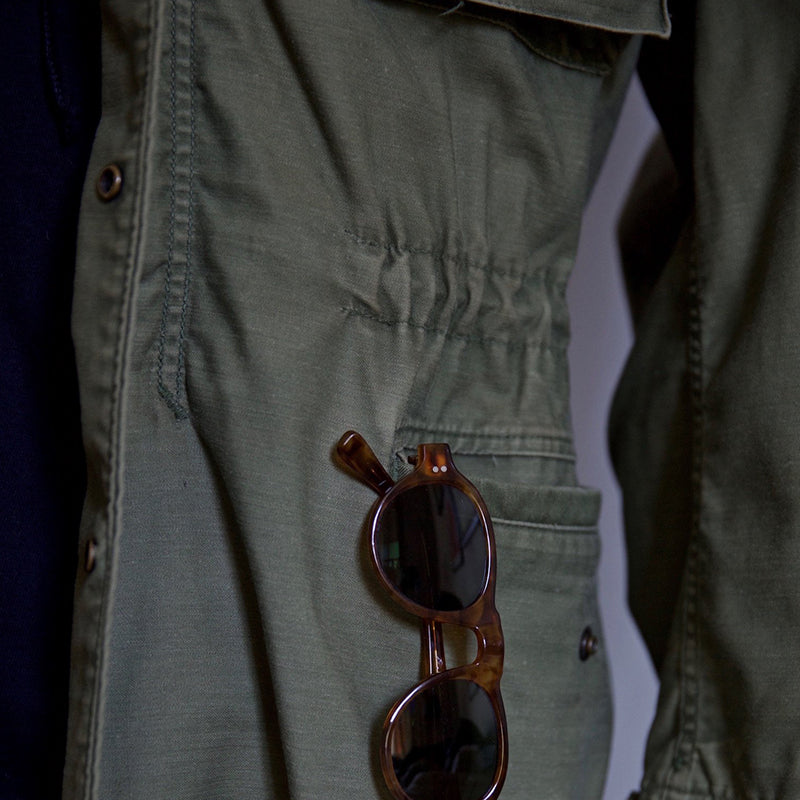 Détail veste M-65 Field homme : poches fonctionnelles, col montant. Style militaire résistant et urbain, parfait saisonnière.