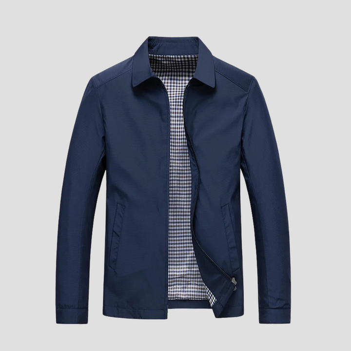 "Veste zippée imperméable homme, style urbain, couleur marine, col pointu, doublure à carreaux, fermetures discrètes."