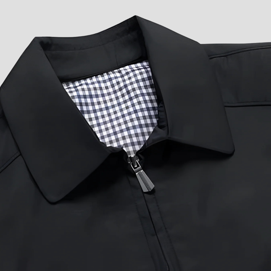 "Veste zippée imperméable homme, style urbain, couleur marine, col pointu, doublure à carreaux, fermetures discrètes."