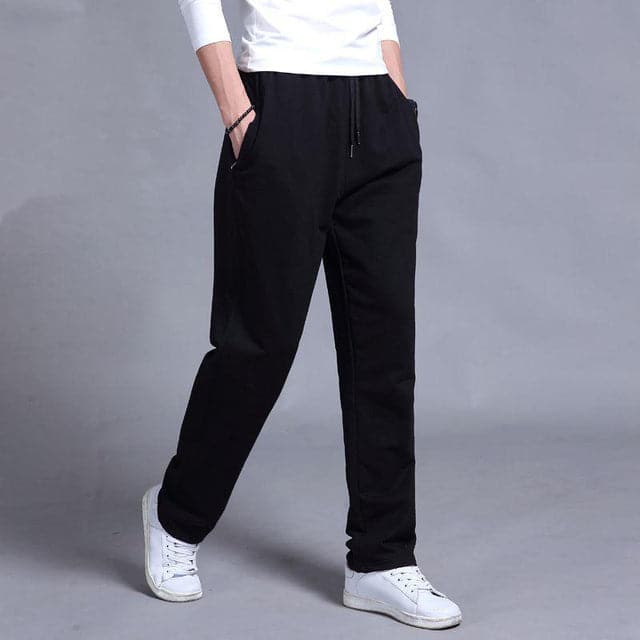 "Vue avant pantalon fuselé noir pour homme, design élégant et moderne, confort optimal, poches zippées, coupe ajustée"