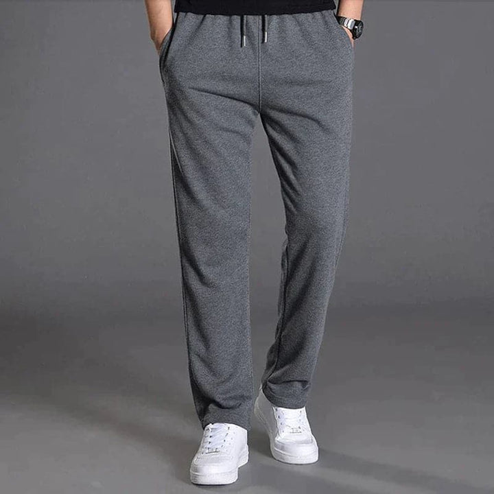 "Vue avant pantalon fuselé noir pour homme, design élégant et moderne, confort optimal, poches zippées, coupe ajustée"